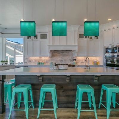 Mint green stools and pendant lights add charm to showcase kitchen